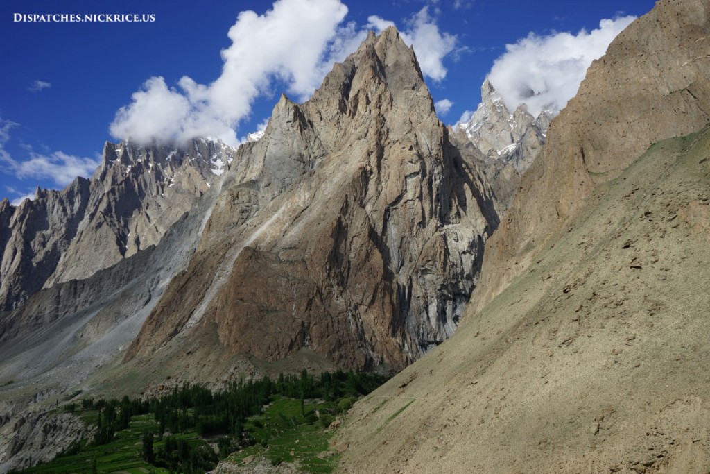 An enormous rocky peak that dwarfs the small village below